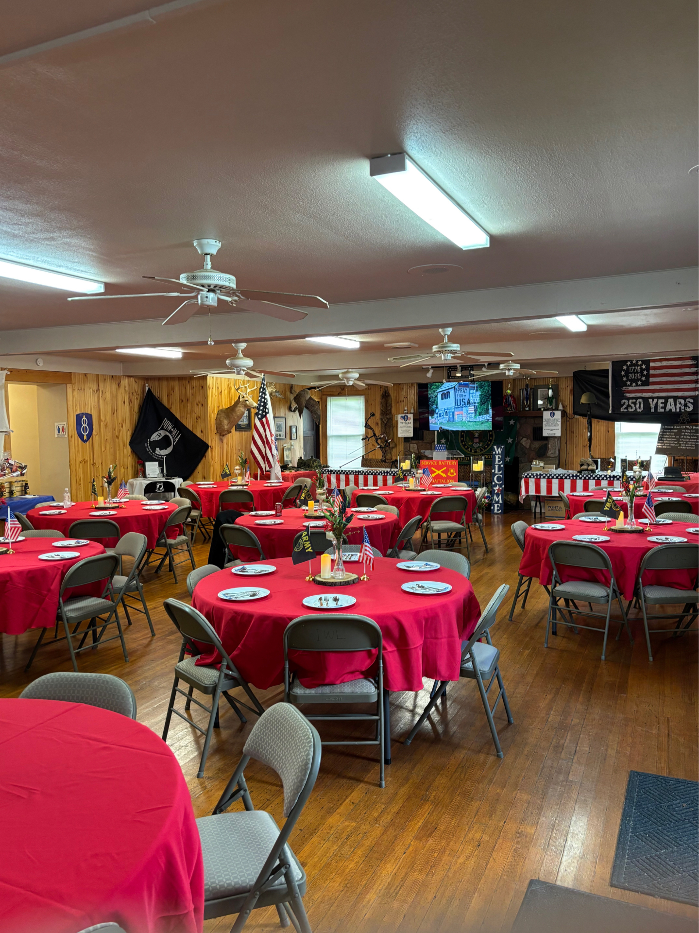 Banquet hall set with round tables and red linens at the Izaak Walton League clubhouse
